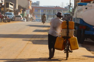 A man pushes his bicycle with fuel jerrycans along a street in Juba